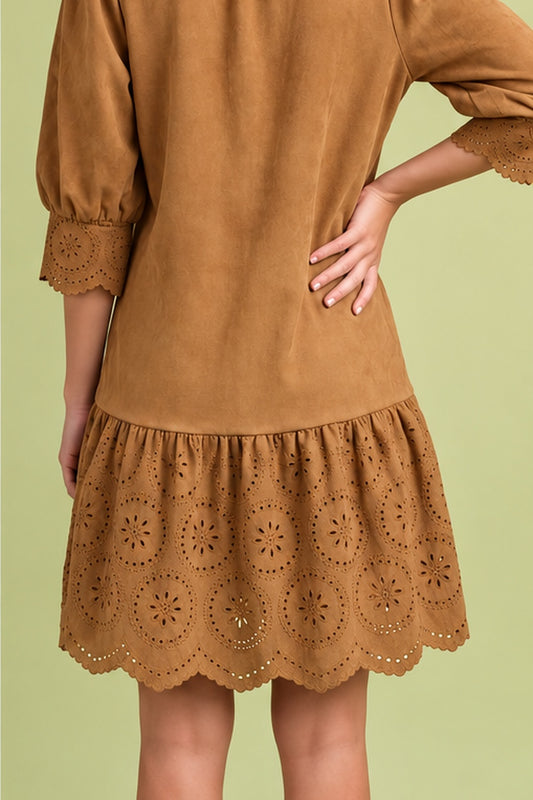 Back view of camel suede-look dress showing relaxed silhouette, eyelet cuffs, and scalloped ruffle hem