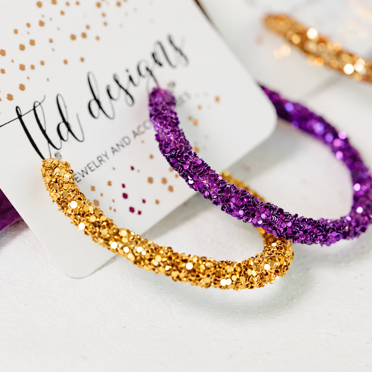 Purple and gold hoop earrings with sparkling textured finish