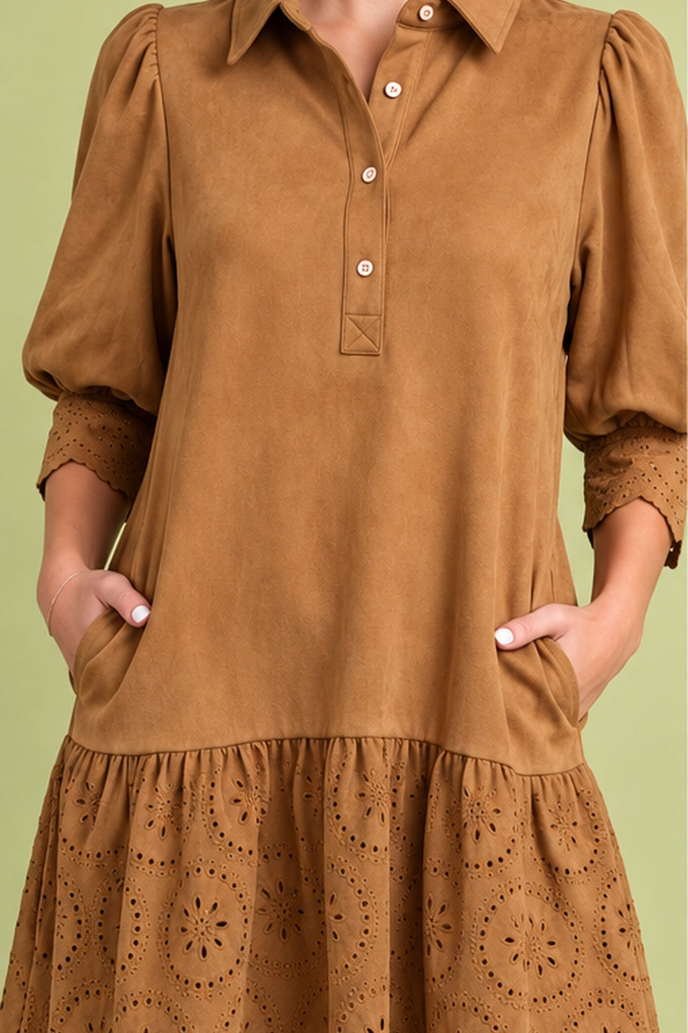 Front view of camel suede-look dress with collared button front, puff sleeves, side pockets, and eyelet ruffle hem