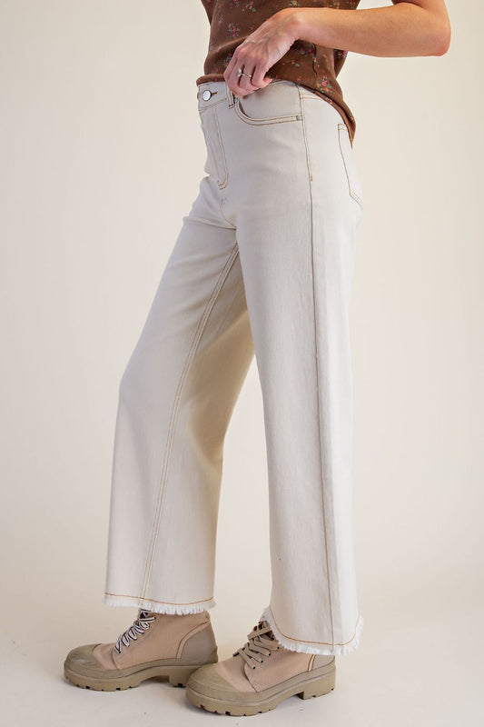 Front side view of ecru high-waisted straight-leg twill pants with frayed hems