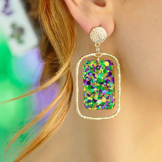 Nola Nights dangle earring with purple, green, and gold confetti acrylic inside an open gold-tone rectangular frame